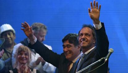 Carlos Zannini y Daniel Scioli saludan a los presentes en un mitin.