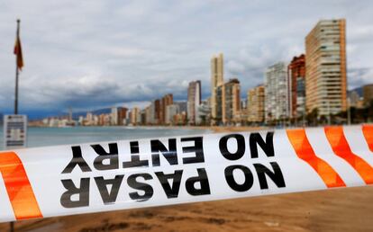 Un cordón policial impide el paso a la playa de Levante de Benidorm, que muestra una estampa muy alejada de la habitual, muy diferente incluso de los meses invernales de moderada ocupación.