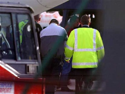 Un policía custodia a un detenido, sospechoso del asesinato del joven Anthony Walker, en Liverpool.