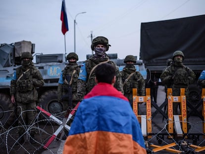 Un hombre con la bandera armenia, el día 24 frente a las fuerzas de paz rusas a las afueras de Stepanakert (Nagorno-Karabaj).