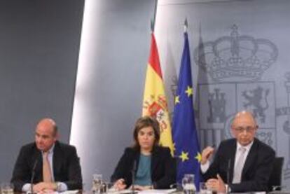 La vicepresidenta del Gobierno, Soraya Sáenz de Santamaría, acompañada del ministro de Economía, Luis de Guindos, y el de Hacienda, Cristóbal Montoro, en la rueda de prensa posterior al consejo de ministros que ha aprobado los Presupuestos Generales del Estado 2015.