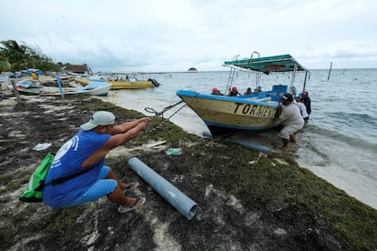 Hombres sacan un bote del agua como medida preventiva ante la llegada de Helene a la península de Yucatán, este martes en Cancún.