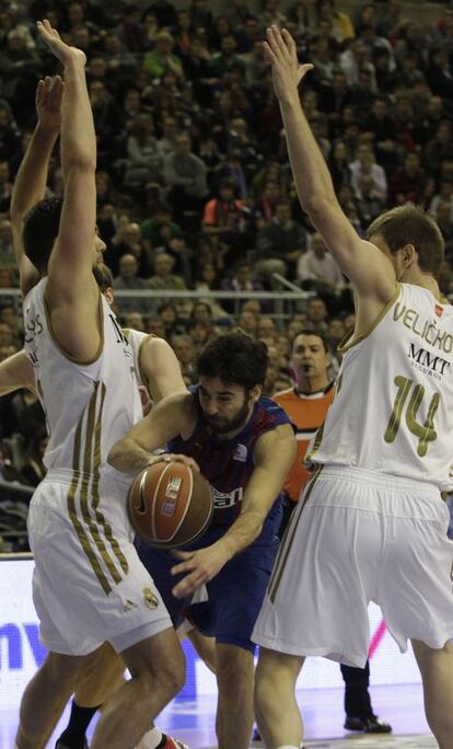 Juan Carlos Navarro busca el pase entre Felipe Reyes y Velickovic