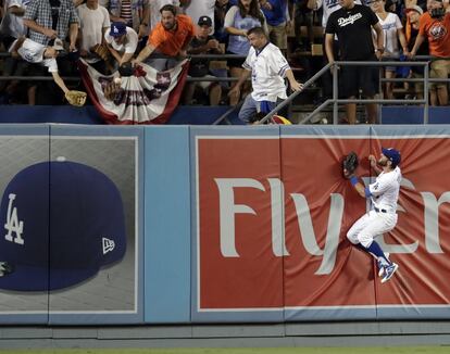 Chris Taylor (derecha) de Dodgers intenta atrapar la pelota tras un jonrón bateado por Marwin Gonzalez durante el segundo juego de la Serie Mundial de las Grandes Ligas de Béisbol (MLB) en el estadio de los los Dodgers, en Los Ángeles, California (EE UU).