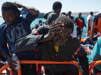 Un migrante rescatado de una patera se refresca mientras espera ser trasladado al puerto de Tarifa.