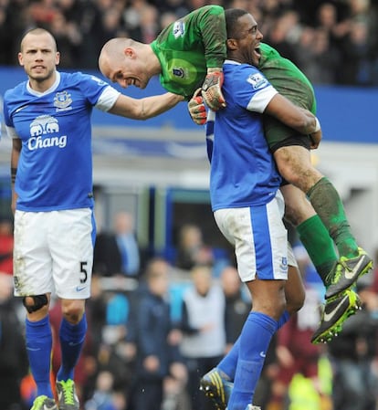 El defensa francés del Everton Sylvain Distin (izquierda) levanta al portero de su equipo Jan Mucha en el partido ante el Manchester City que se ha disputado en el estadio Goodison Park. Los 'toffees', sextos a solo dos puntos del Arsenal, luchan por conseguir un billete para la Liga de Campeones.