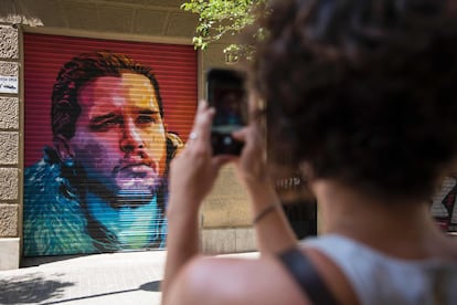 Una mujer toma una fotografía de una pintura que representa al actor Kit Harington caracterizado como Jon Nieve en la serie 'Juego de tronos'.