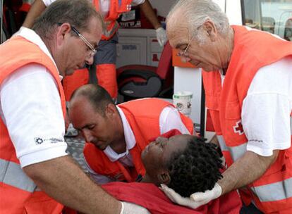 Una de las inmigrantes recibe atención de los servicios sanitarios a su llegada al puerto de Motril