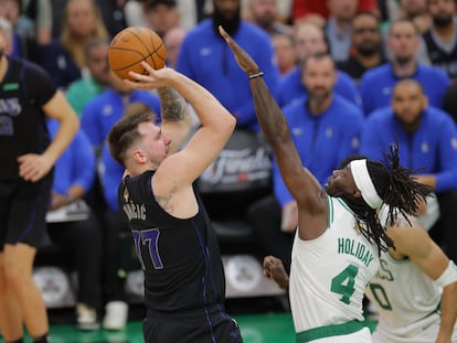 Luka Dončić lanza a canasta en el partido de este jueves, ante la oposición de Jrue Holiday.