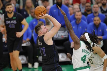 Luka Dončić lanza a canasta en el partido de este jueves, ante la oposición de Jrue Holiday.