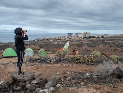 Una activista vigila los movimientos de los operarios durante la acampada contra la construcción de la urbanización turística Cuna del Alma en Adeje (Tenerife).