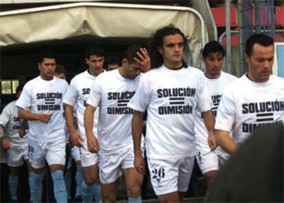 Los jugadores del Compostela saltan al campo, en enero pasado, pidiendo la dimisión de su presidente en una camiseta.