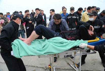 Uno de los supervivientes es evacuado a su llegada a la isla Jindo (Corea del Sur) El Gobierno de Corea del Sur elevó a 290 el número de desaparecidos en el hundimiento del barco tras informar que eran solo 100 los desaparecidos.