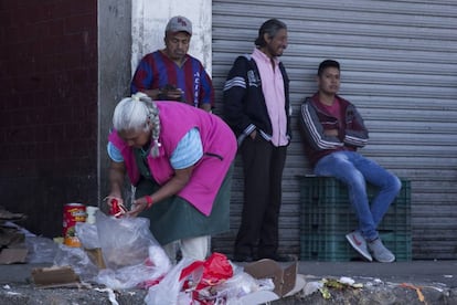 Una mujer revisa bolsas de desperdicios en la Ciudad de M&eacute;xico.