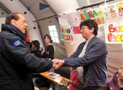 Berlusconi saluda a una señora en Monticchi, en uno de los campamentos que se han levantado en los alrededores de L'Aquila