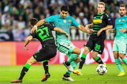 El jugador del Barcelona Luis Suárez (c) disputa el balón con el jugador del Borussia Moenchengladbach Julian Korb (i).