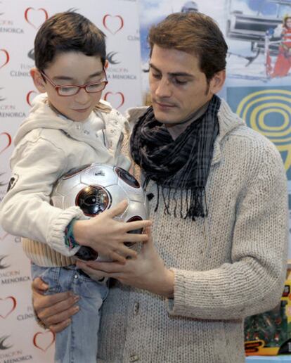 Iker Casillas sostiene en brazos a un niño durante el acto de la Fundación Clínicas Menorca.