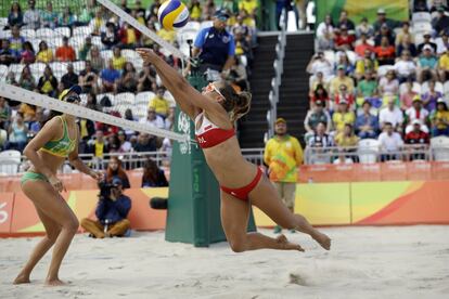 La polaca Monika Brzostek (derecha) se tira para devolver el balón de voleibol playa en el partido contra Brasil.