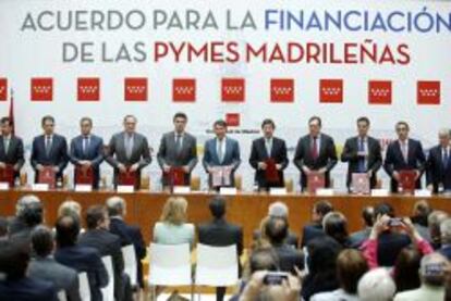 El presidente de la comunidad de Madrid, Ignacio Gonz&aacute;lez (c), junto al ministro de Industria, Jos&eacute; Manuel Soria (5i), tras la firma de un convenio con siete de las principales entidades de cr&eacute;dito (BBVA, Banco Santander, Banco Popular, Banco Sabadell, Bankia, Caixabank y Bankinter) y la Sociedad de Garant&iacute;a Rec&iacute;proca Avalmadrid, en junio de 2013. 