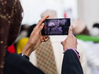 Una mujer hace fotograf&iacute;as con su &#039;smartphone&#039; durante las fiestas Maulidi en Kenia. 
 
 