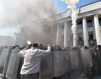 Lanzamiento de botes de humo a la policía que protege la entrada al Parlamento de Kiev (Ucrania).