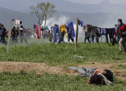 Un hombre cae rendido en el suelo durante la protesta con la policía macedonia.