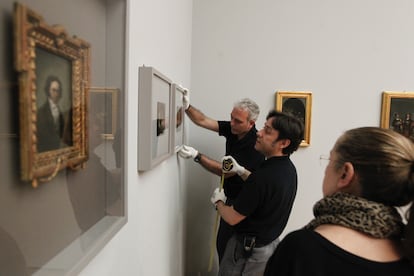 Los operarios del Prado, bajo la atenta mirada de la experta en arte Manuela Mena, ultiman la colocación de las obras que componen la nueva muestra temporal del museo.