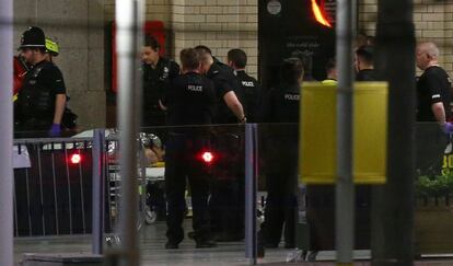 Una persona es llevada en camilla en el interior de la Victoria Station.