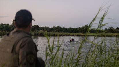 Un agente de la policía estatal de Texas observa a un colega extraer a una persona del cauce de Río Grande en una moto acuática, en Mission, Texas (Estados Unidos), el 13 de junio.