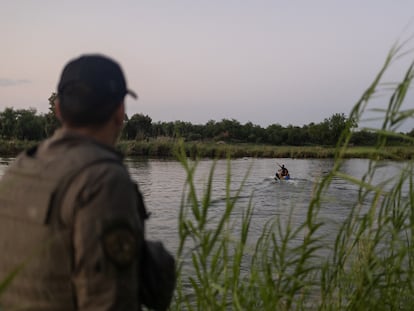 Un agente de la policía estatal de Texas observa a un colega extraer a una persona del cauce de Río Grande en una moto acuática, en Mission, Texas (Estados Unidos), el 13 de junio.