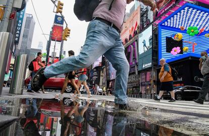 Un ciudadano evita un charco en Time Square durante las lluvias que han caído debido a la tormenta tropical 'Henry', en la ciudad de Nueva York.