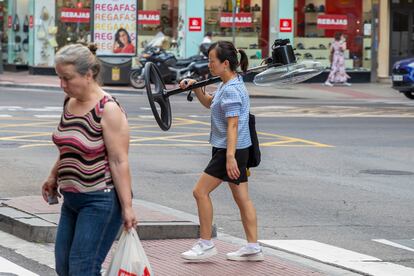 Una mujer carga con un ventilador en Zaragoza.