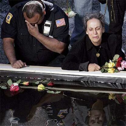 Dos personas recuerdan a las víctimas del 11-S ante el estanque instalado en la <b><i>zona cero</b></i> de Nueva York.