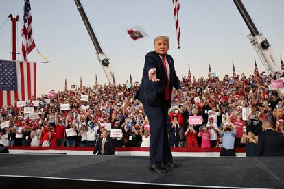 Trump arroja mascarillas a la multitud mientras sube al escenario para dar un mitin electoral, la pasada madrugada en Sanford (Estados Unidos).