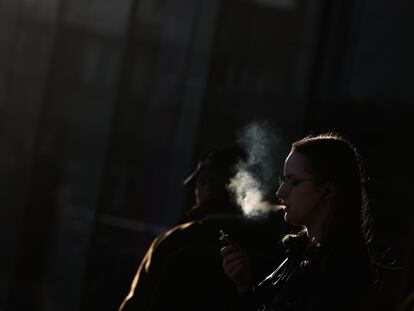 Una mujer fumaba en una calle de Cracovia, en marzo.