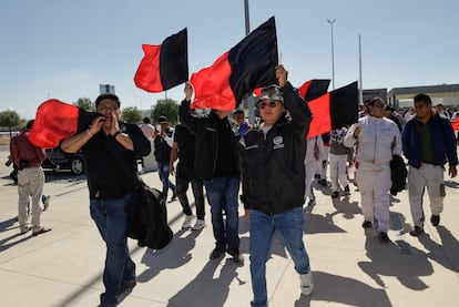 Trabajadores de Audi ondean banderas rojinegras en las instalaciones de la empresa, el 24 de enero en Puebla.