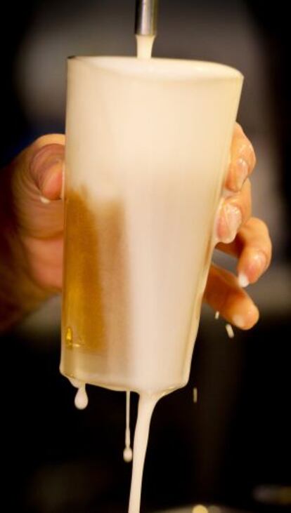 A bartender pours a beer in a Madrid restaurant.