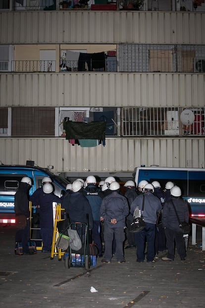Tècnics d'Endesa amb els agents de la policia durant l'entrada als pisos.