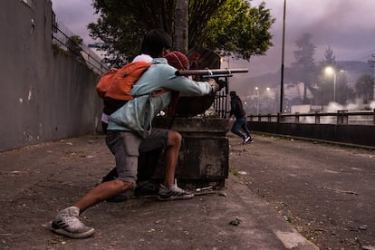 Un manifestante apunta un cañón casero mientras otro lo escuda, durante un enfrentamiento con la policía, en Quito, el 22 de junio.