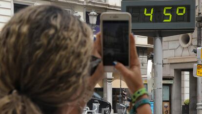 GRANADA 09/08/2023,- Una mujer fotografía la temperatura de un termómetro en Granada, este miércoles, una jornada marcada por las altas temperaturas en todo el país. EFE/ Pepe Torres.