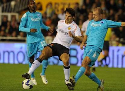 Morientes disputa un balón con dos rivales en el partido de anoche en Mestalla.