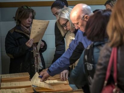 Votants seleccionen paperetes al col·legi Claret, de Chamartín (Madrid).
