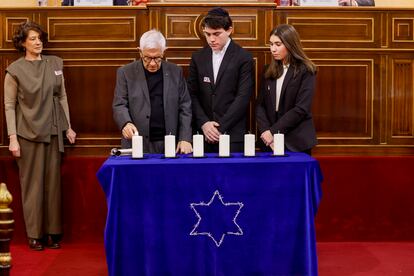 El superviviente Albert Barbouth (i), y Clara y David, dos alumnos del Centro Ibn Gabirol - Colegio Estrella Toledano, encienden una de las velas durante el acto de conmemoración del Día de la Memoria del Holocausto y la Prevención de los Crímenes contra la Humanidad, organizado por la Federación de Comunidades Judías de España y el Centro Sefarad-Israel, este lunes en el Senado en Madrid.