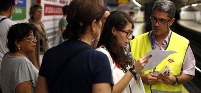 Varias usuarias del metro preguntan a un empleado qué camino seguir.