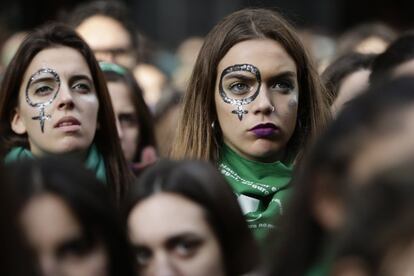Dos jóvenes maquilladas y con pañuleos verdes participan de la manifestación a favor de la ley de despenalización del aborto frente al Congreso argentino.