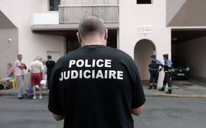 Un agente de la Policía Judicial, junto al edificio donde han muerto cinco miembros de la misma familia en Pau (Francia).