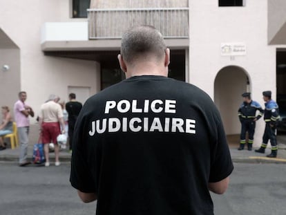 Un agente de la Policía Judicial, junto al edificio donde han muerto cinco miembros de la misma familia en Pau (Francia).