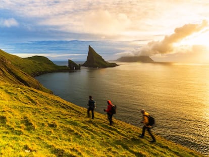 Excursionistas rumbo a Drangarnir, dos peñones de roca junto a la isla de Vágar, en las Feroe.