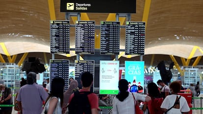 Passageiros observam informações sobre voos no terminal 4 do aeroporto Adolfo Suárez, em Madri, neste domingo.