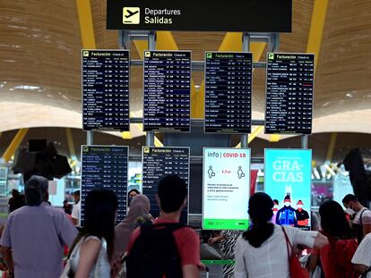 Passageiros observam informações sobre voos no terminal 4 do aeroporto Adolfo Suárez, em Madri, neste domingo.